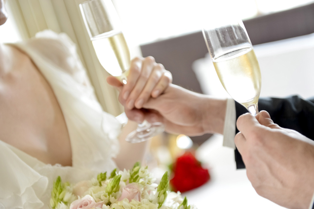 mãos de noivos com taças de champagne