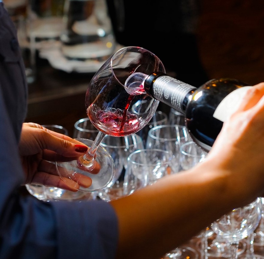 Mulher servindo vinho na taça