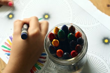 Criança pintando desenho de recreação com giz de cera
